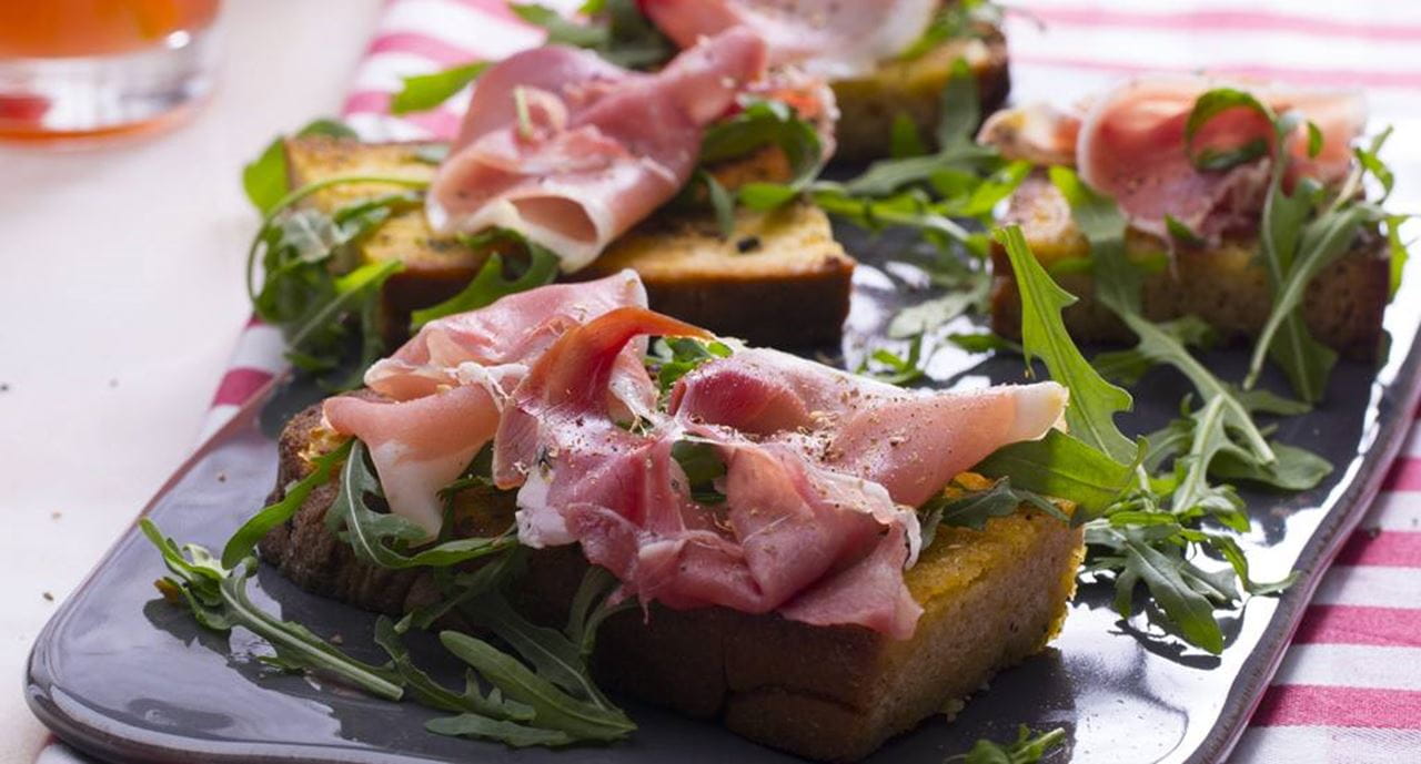 recipe image Bruschettas de pão de milho com presunto e rúcula